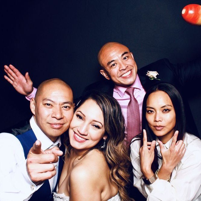 Wedding guests pointing at the camera on a black backdrop
