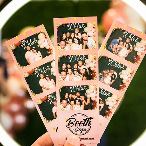 A guest holding custom Chloe photo strips in front of the ring light